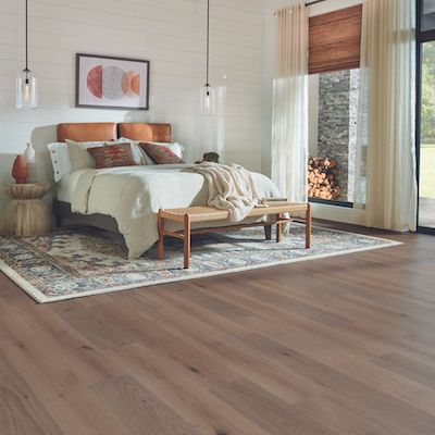 area rug under a bed in a cozy rustic bedroom